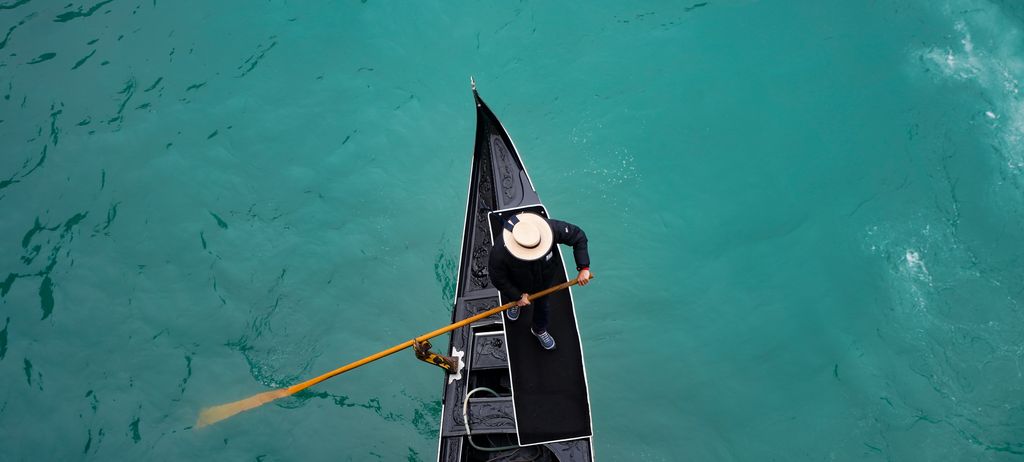 A gondola on emerald water, seen from directly above