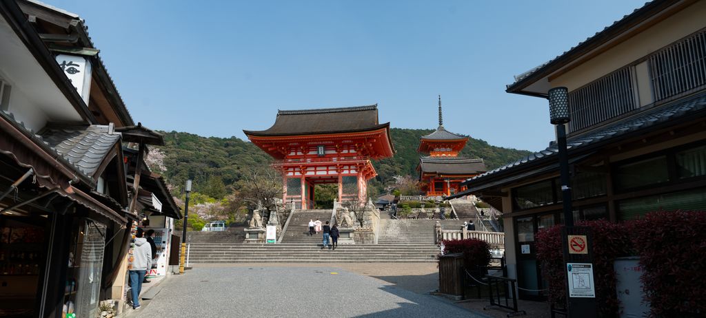 A vermilion gate and three-storied pagoda at the end of an approach