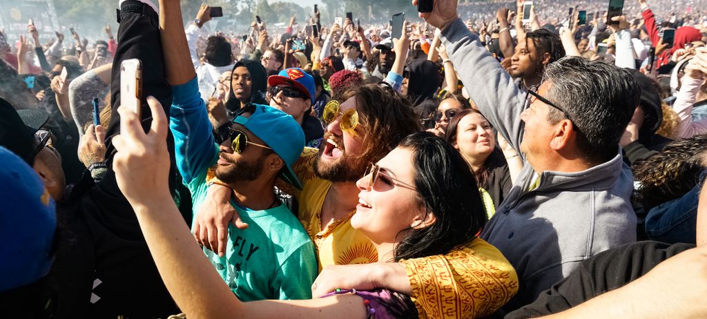 A dense crowd with phones held high